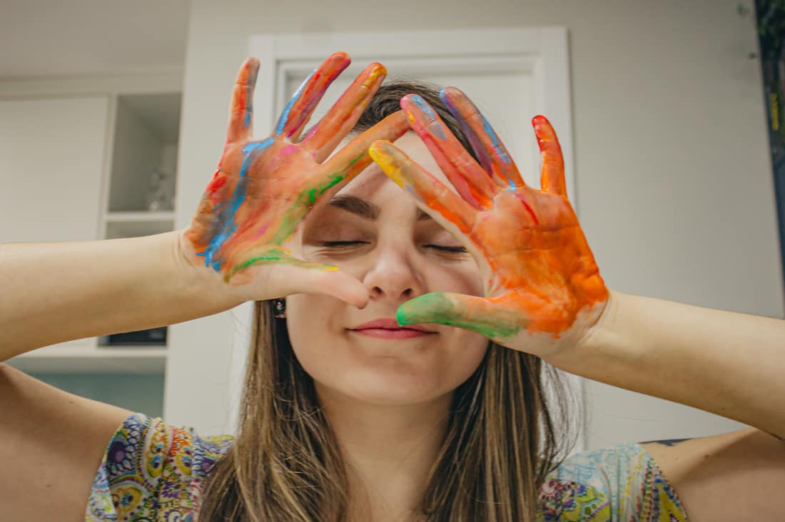 Mãos pintadas com tinta, expressão criativa em arteterapia